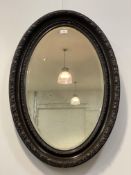 An early 20th century oval wall hanging mirror with floral carved frame. 84cm x 58cm.