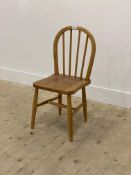 A mid 20th century child's beech Windsor type chair, with hoop and spindle back above a saddle seat,