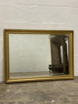 A traditional floral moulded gilt composition wall mirror with bevelled plate 98cm x 74cm.