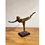 A modern bronzed finish resin sculpture of a figure in ballet pose raised on base H x 31cm L x 44