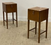 A pair of mid century mahogany bedside tables, each fitted with a fall front cupboard above a