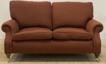 A traditional walnut framed two seat sofa, the frame and squab cushions upholstered in terracotta