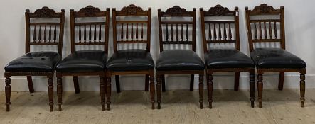 A set of six late Victorian floral carved walnut dining chairs with black leather upholstered
