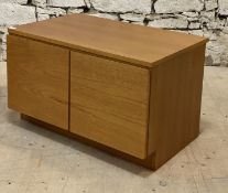 A mid century teak low cabinet, fitted with two doors opening to a division behind. H52cm, W85cm,