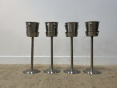 A set of four stainless steel twin handled champagne or ice buckets, each standing on a conforming