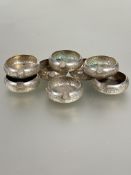 A set of eight Eastern white metal individual table ash trays of circular form with chased scrolling