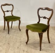 A pair of Victorian rosewood dining chairs, each with a floral carved crest rail and bar back