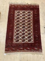 A hand knotted Bokhara rug, the ivory field with lozenge and gul motif within a guarded border 210cm
