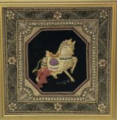 A framed hand-stitched work of an Indian style horse on a black background enclosed within foliate