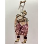 A 1920's carved wood Burmese male puppet with inset glass eyes dressed in later short wasted