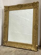 An early 20th century and later gilt composition framed wall hanging mirror in the Baroque style,