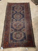 An antique Turkman / Afghan rug, the deep blue field with six gul motif within a madder border.