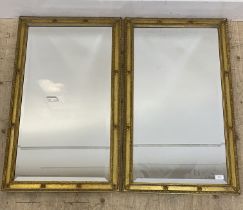 A pair of gilt composition framed wall hanging mirrors 96cm x 55cm.