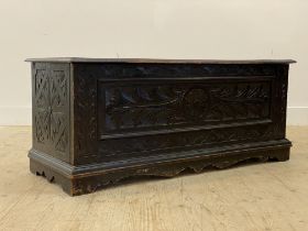 An early 20th century oak hall bench, the hinged top with later squab cushion, above a carved