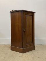 A early 20th century walnut bedside cupboard, the ledge back over panelled door enclosing a shelf,