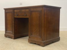 An Edwardian oak twin pedestal desk, the tooled and distressed inset leather writing surface above a