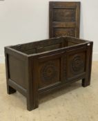 An 18th century oak coffer of pegged and jointed construction, the three panel lid on strap