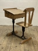 A late 19th century pine school desk, the double hinged writing slant above a storage well and seat,