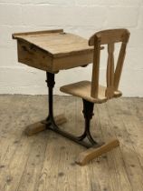 A late 19th century pine school desk, the double hinged writing slant above a storage well and seat,