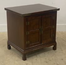 A Chinese style stained hardwood bedside cabinet, fitted with two panelled doors enclosing a