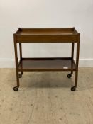 An early 20th century mahogany drinks trolley, the galleried top above a drawer, raised on square