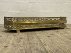 A 19th century pierced brass fire fender standing on paw supports. L114cm.