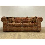 A Duresta two seat Chesterfield sofa, complete with squab and scatter cushions, raised on compressed