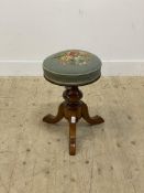 A Victorian walnut rise and fall piano stool with circular seat upholstered in embroidered fabric,