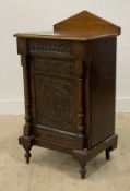 A 19th century oak pedestal cabinet, with arched ledge back over carved frieze drawer and single