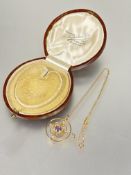 A Edwardian 9ct gold circular open work pendant set central amethyst with a scrolling border and
