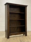 An early 20th century oak open bookcase, the dentil frieze above three shelves, raised on panel