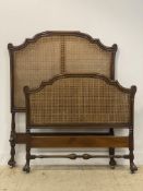 A 1930's single bed head / foot board, the scroll carved and moulded walnut frame enclosing