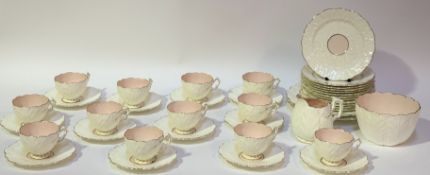 A near complete pink and white floral shaped tea service with gilt decoration comprising, twelve tea