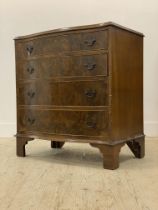 An early 20th century figured walnut serpentine chest of four long graduated drawers, raised on