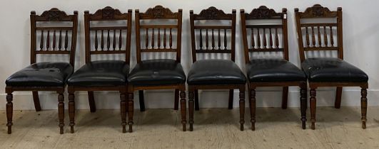 A set of six late Victorian floral carved walnut dining chairs with black leather upholstered