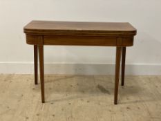 A George III mahogany fold over tea table, the top edge, frieze and square tapered supports with