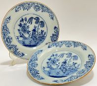 A pair of Chinese blue and white dishes the central roundels painted with garden scenes, willow tree