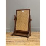 A mid 20th century walnut framed vanity mirror, the rectangular plate swivelling between two