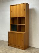 A mid century teak two part side cabinet, the top fitted with two sliding doors and a combination of