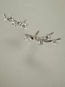 A pair of white gold diamond set shooting star style earrings set five graduated diamonds L x 1.5cm