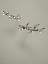 A pair of white gold diamond set shooting star style earrings set five graduated diamonds L x 1.5cm