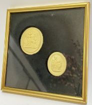 Two low/bas-relief carved wax medallions depicting classical scenes, housed in a glazed and gilt