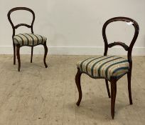A pair of Victorian rosewood balloon back side chairs, each with an upholstered seat and raised on