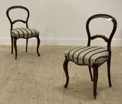 A pair of Victorian rosewood balloon back side chairs, each with an upholstered seat and raised on