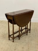 An early 20th century mahogany gate leg table, the oval top with gadrooned edge on turned and