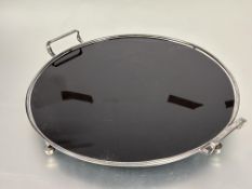 A 1930s chrome plated circular two handled farmed drinks tray with inset black vitralite panel