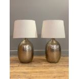 A pair of contemporary planished metal lamp bases, each complete with an oatmeal linen shade. H60cm.