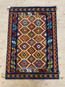 A Chobi kilim rug, the orange field with repeating design enclosed by running dog band to each side.