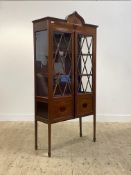 An Edwardian mahogany display cabinet, the arched cornice above a frieze inlaid with boxwood