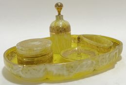 A gilt yellow glass dressing table set with raised scrolling foliate decoration to rim, comprising a